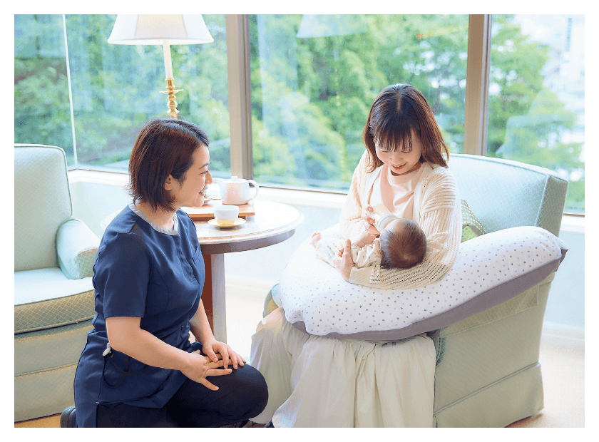 読者モデルの陽菜さんが凜果（りんか）ちゃん（2ヵ月）を抱っこしながら、専門スタッフと話している画像
